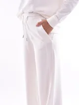 Pantalón de jogging color beige, de corte ancho y tiro alto, con cintura elástica ajustable con cordón.