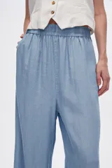 Pantalón azul de lyocell, de corte ancho y tiro alto, con cintura elastizada y bolsillos laterales.