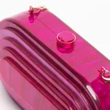Cartera de mano tipo sobre, forma ovalada, color fucsia con efecto marmoleado. Presenta un diseño con capas concéntricas en relieve y cierre superior con broche dorado. Incluye cadena metálica dorada para usar al hombro.