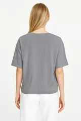 Remera gris de poliéster, de manga corta, corte holgado y cuello redondo.