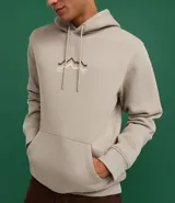 Hoodie cerrado de algodón con felpa, color beige claro, corte comfort. Presenta capucha con cordón ajustable, bolsillo canguro y puños y ruedo ajustados. Estampa minimalista de montañas en el pecho con líneas en tonos marrón, negro y rosado.