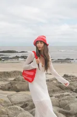 Cartera tejida a crochet con hilo 100% de algodón, con diseño a rayas y volados bordeando la cartera extendiéndose hacia la manija.