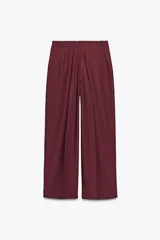 Pantalón de vestir color borgoña, de tiro alto y pierna ancha, con bolsillos laterales y cierre frontal con cremallera y ganchos metálicos.