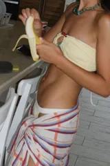 Pareo rectangular con estampado a cuadros en tonos celeste, naranja y blanco, con detalle de flecos en los bordes.