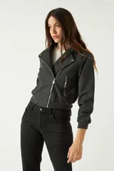 Campera corta color marrón chocolate, con textura tipo gamuza, cuello clásico, cierre frontal asimétrico con cremallera metálica y bolsillos laterales con cremallera.