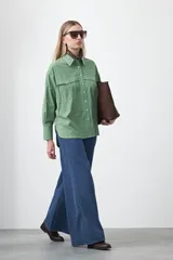 Camisa blanca de algodón con diseño utilitario y calce relajado. Presenta dos bolsillos frontales de estilo cargo con tapa y costuras a contratono.