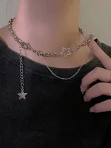 Gargantilla plateada de eslabones gruesos con doble cadena, dije de estrella calada con strass y dije de estrella lisa colgante.