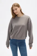 Buzo color beige de corte ancho y cuello redondo.