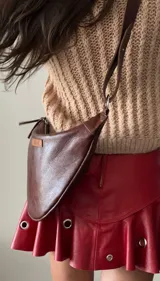 Riñonera de cuero marrón con correa ajustable para usar como bandolera o cinturón. Diseño minimalista con logo de la marca en el frente. Hecha a mano con cuero 100% natural.