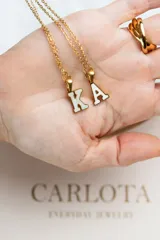 Collar con dije de letra inicial en acero quirúrgico con baño de oro 18k y cadena dorada fina.