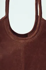 Bolso tipo tote bag de gamuza color marrón oscuro, con asas de hombro largas y estructura rectangular.