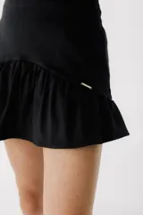 Minifalda marrón de corderoy con volados en el ruedo y etiqueta dorada con logo en la cintura.