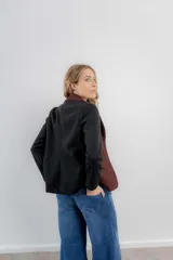 Blazer gris a cuadros con mangas largas negras.