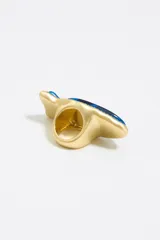 Anillo azul con forma de pez, con borde dorado y pequeños brillantes.