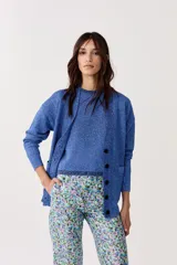 Cardigan de lurex azul con escote en V, botones frontales y bolsillos.