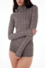 Conjunto de top de cuello alto y shorts ajustados con estampado geométrico en tonos beige y negro.