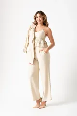 Top color beige con breteles finos, escote en V y volados en el ruedo.