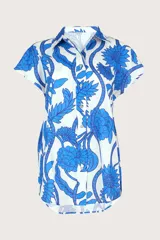 Camisa blanca con estampado floral azul, de corte recto, cuello camisero y mangas cortas.