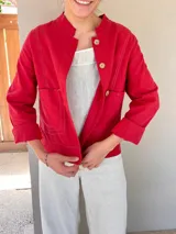 Chaqueta color marrón claro de lino y algodón, con cuello mao, cierre frontal con botones de madera y bolsillos laterales.