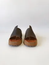 Sandalias de cuero color chocolate, con tira ancha sobre los dedos y suela de goma con plataforma.