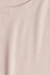 Musculosa color rosa claro, de punto acanalado, con cuello redondo y sisas anchas.