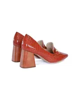 Zapato de vestir tipo mocasín color caramelo con estampado de cocodrilo, detalle metálico dorado en la parte delantera y taco geométrico color madera.