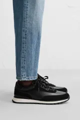 Zapatilla deportiva negra con detalles en piel y acabado serraje.