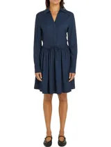 Vestido corto camisero azul marino de Tommy Hilfiger, con cuello italiano, mangas largas con puños abotonados, cinturón anudable en la cintura y logo metálico en el bajo.