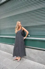 Vestido largo negro con estampado de lunares blancos, breteles finos y escote en V.