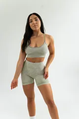 Conjunto deportivo color verde oliva, compuesto por un top corto de mangas cortas y un short ajustado de tiro alto.