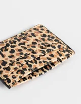 Tarjetero de cuerina con estampado animal print en tonos beige y marrón.