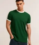 Remera de algodón de corte regular, color blanco hueso, con cuello redondo y ribete negro. Presenta un diseño de doble raya negra en las mangas y ribetes negros en el cuello y los puños de las mangas.