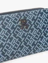 Billetera plegable Tommy Hilfiger con estampado integral, múltiples ranuras para tarjetas, compartimento para billetes, bolsillo exterior con cremallera y logo TH en la parte delantera.