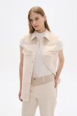 Chaleco color crema con detalles en tejido de espiga en la parte superior y bolsillos.