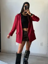 Blazer color rojo con solapas de muesca, cierre frontal con un botón y bolsillos de parche. Corte holgado.