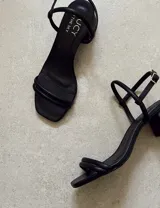 Sandalias doradas de fiesta con tiras finas y taco cuadrado bajo.