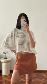 Short pollera color negro confeccionado en viscosa, poliéster y lino, con cierre de botón lateral.