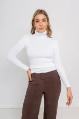 Polera blanca de tejido acanalado, cuello alto y corte relajado.
