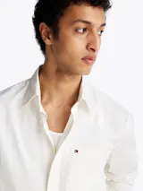 Camisa blanca de sarga de puro algodón teñido en prenda, con cuello con botones, bolsillo de parche en el pecho y puños redondeados con botón.