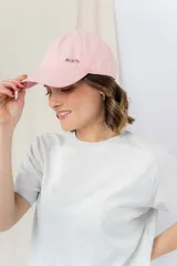 Gorra rosa de algodón con visera curva y logo 'peach' bordado en plateado.