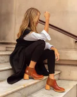 Bota corta de cuero color marrón con textura tipo reptil, paneles laterales de gamuza y elástico, tacón de madera y tirador trasero.