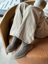 Bota corta color taupe de cuero, con suela cosida de 3 cm y cierre frontal con cremallera. Forrada con felpa.