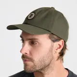 Gorra de béisbol verde militar con logo bordado en parche circular blanco y negro.