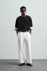 Camiseta negra de corte holgado, cuello redondo y manga corta. Estampado frontal con diseño abstracto en color blanco.