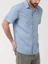 Camisa de manga larga color verde claro, confeccionada en popelina de algodón orgánico. Cuenta con cuello camisero, botones de madera, bolsillo en el pecho con logo bordado y protección UPF +20.