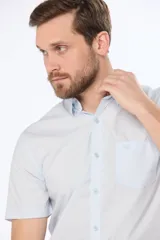 Camisa azul marino lisa de manga corta con cuello abotonado, cierre frontal con botones y bolsillo en el pecho. Confeccionada en algodón.