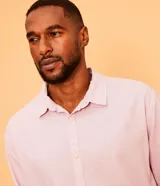 Camisa celeste de lino con cuello camisero, abotonadura frontal y mangas largas.