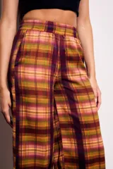 Pantalón de tiro medio y calce recto, confeccionado en poliéster con estampado de cuadros escoceses en tonos burdeos, mostaza, verde oliva y rosado.