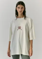 Remerón de jersey de algodón color crudo, de manga corta, con estampa en serigrafía en frente y espalda con la frase "co-creator of love & dreams" y un arco y flecha.