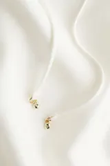 Blusa color blanco hueso, de corte holgado, con cuello de volados y escote en V con lazos. Mangas largas abullonadas con puños elásticos.